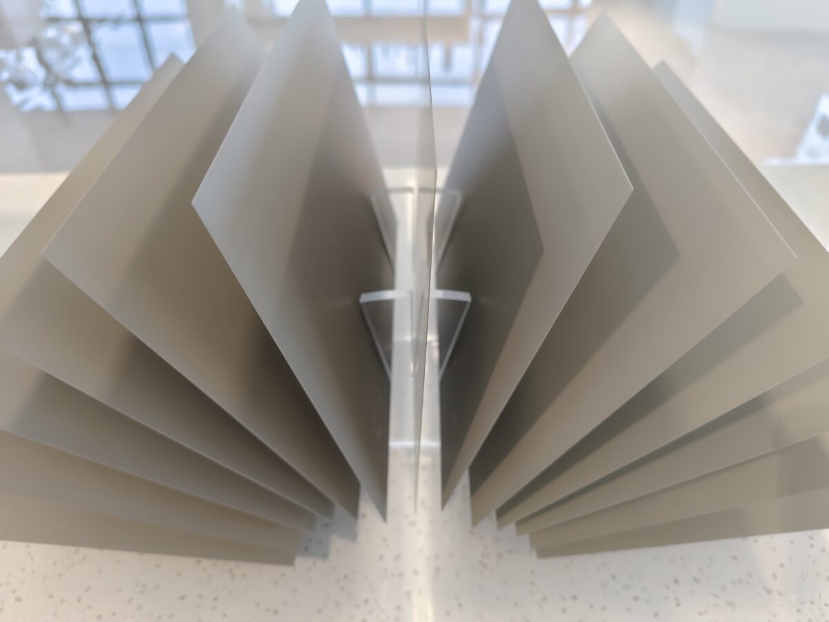 Moderne metallene Wandpaneele in einer dynamischen, geometrischen Anordnung vor natürlichem Licht. Moderne metallene Wandpaneele in einer dynamischen, geometrischen Anordnung vor natürlichem Licht.