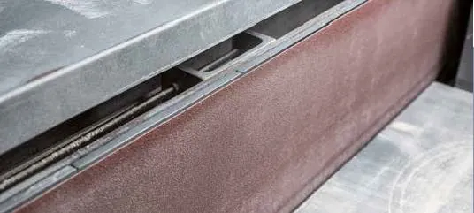 Detailaufnahme einer industriellen Maschine mit metallischer Oberfläche und Leder- oder Schaumstoffpolster. Detailaufnahme einer industriellen Maschine mit metallischer Oberfläche und Leder- oder Schaumstoffpolster.