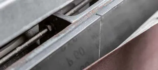 Detaillierte Aufnahme einer mechanischen Edelstahlkomponente mit Schrauben, Bolzen und Verschleißerscheinungen. Detaillierte Aufnahme einer mechanischen Edelstahlkomponente mit Schrauben, Bolzen und Verschleißerscheinungen.